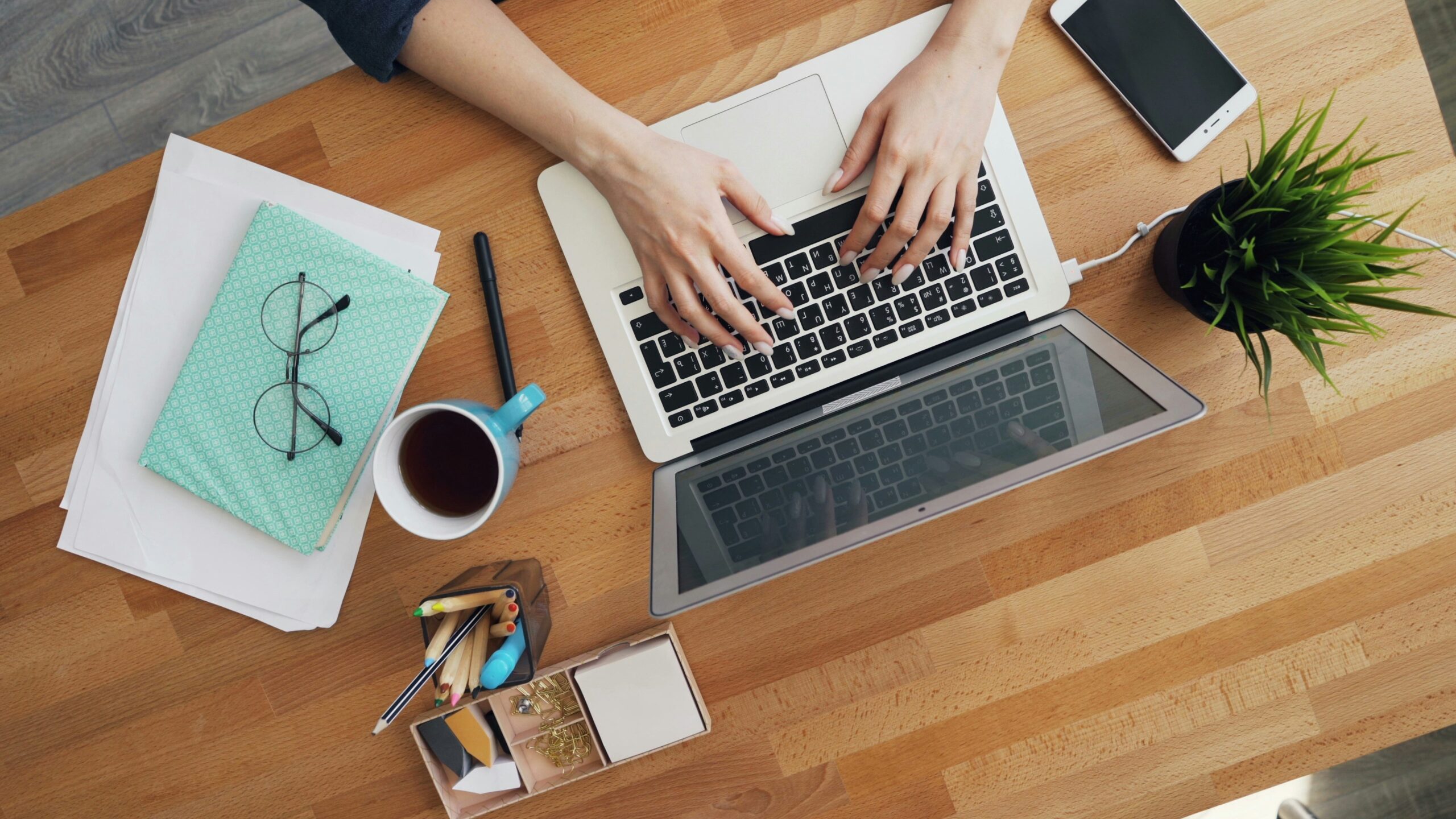 A person writing at a desk with lightbulbs overhead, symbolizing the creation of high-converting copy for landing pages.